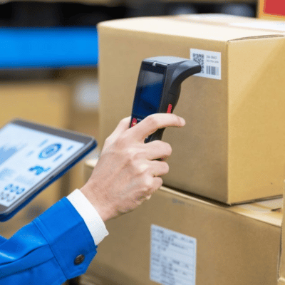 A worker scans a barcode on a box in a warehouse