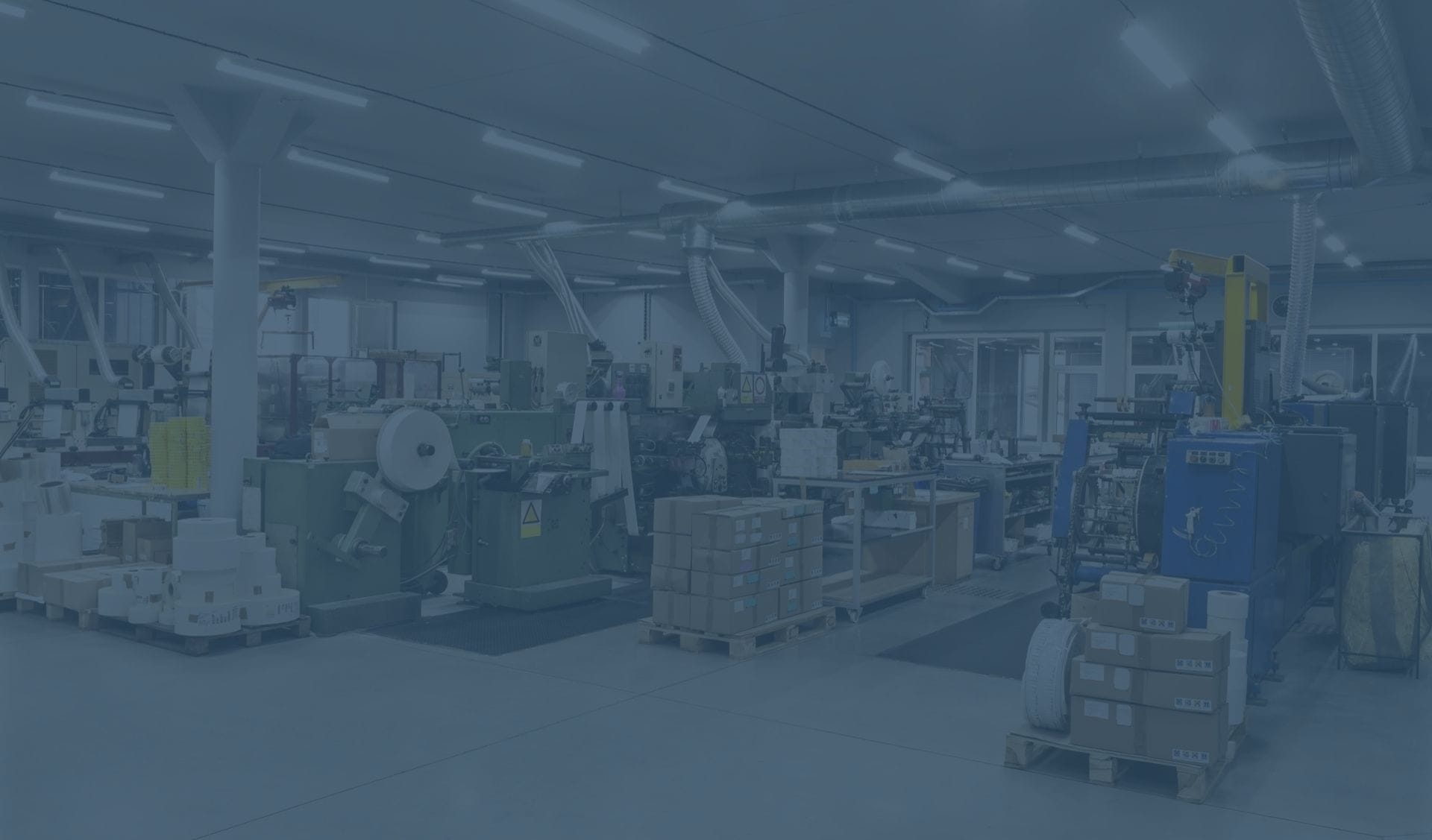 A busy manufacturing environment. Boxes, machines and rolls of labels are visible.